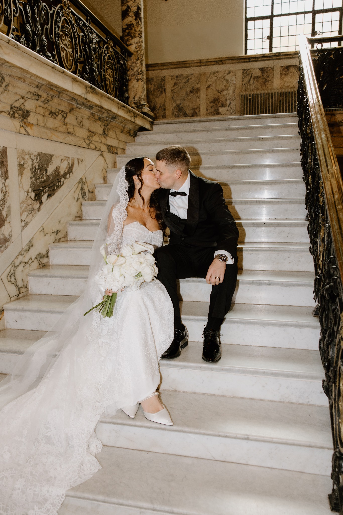 Extra Fleur bridal bouquet with newlyweds on an elegant marble staircase