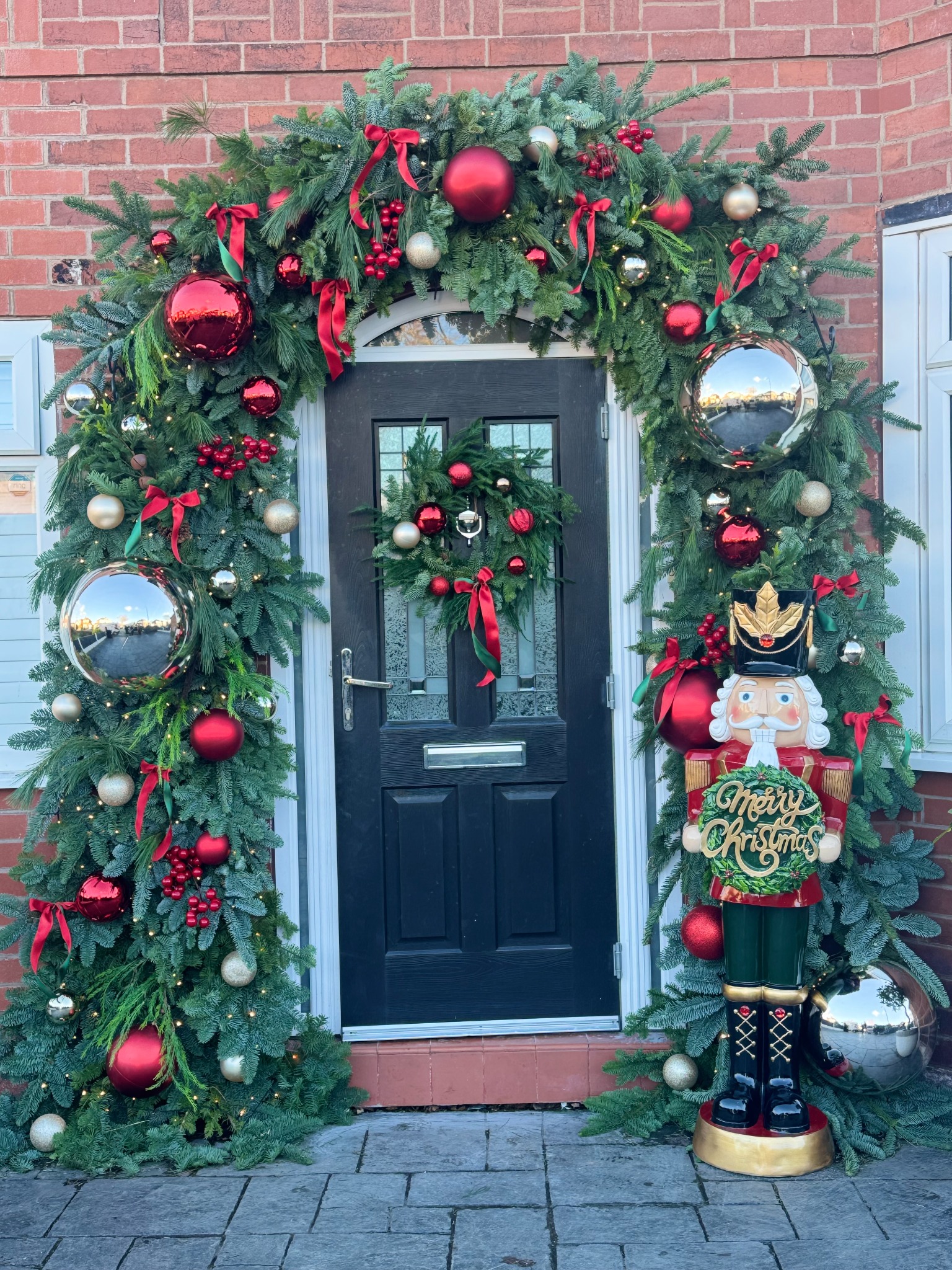 Festive doorway arch with red ornaments, wreath and a nutcracker