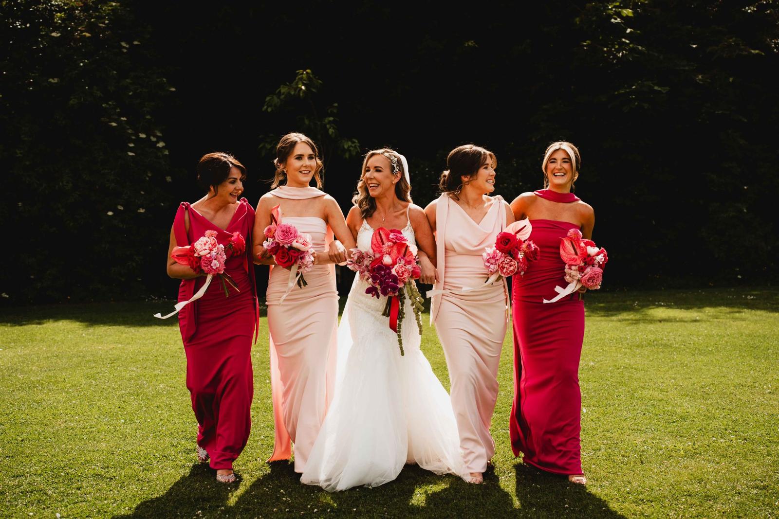 Bride and bridesmaids carrying vibrant pink wedding bouquets
